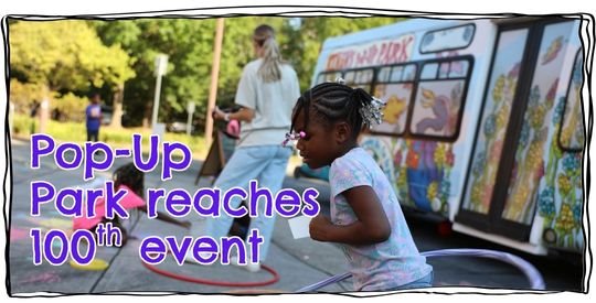Young girl hula hoops in beside the Pop-up Park Bus