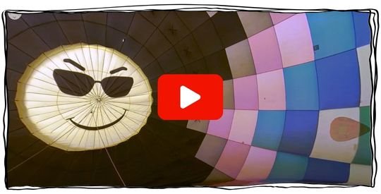 Inside of a partially inflated hot air balloon with multiple colors and a smiley face