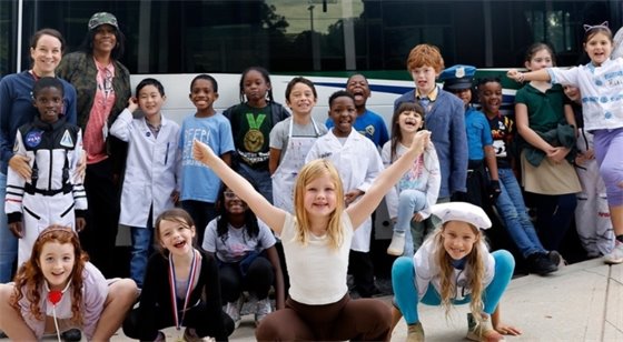 Students posing excitedly outside of a ACC Transit bus