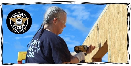 Woman using a power drill to build a wall