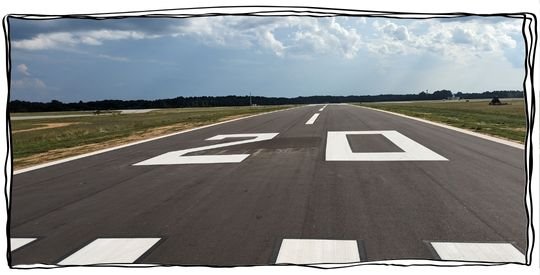 Airport runway with the number 20 painted on the asphalt.
