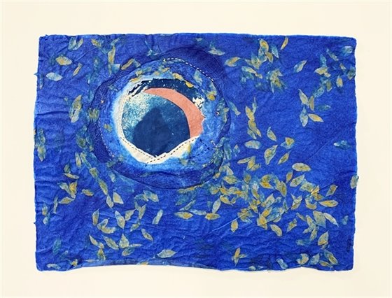 Blue paper artwork with golden leaf shapes around a round circle