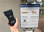 Hand holding a microchip scanner at a microchip scanning station