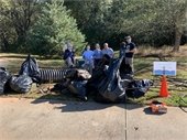 Volunteers in front of a large pile of trash removed from a cleanup site during the 2021 Rivers Alive event.
