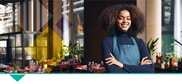 Woman wearing an apron with arms crossed smiling